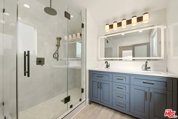 a bathroom with a shower sink and mirror