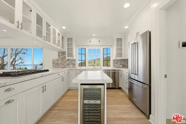 a kitchen with stainless steel appliances granite countertop refrigerator sink and cabinets
