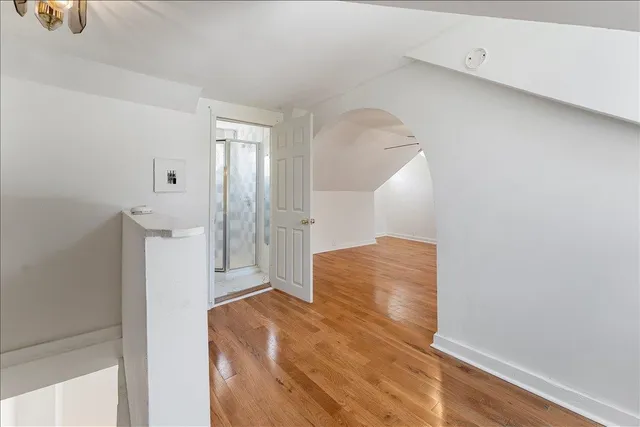 a view of empty room with wooden floor