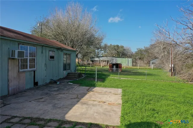 a view of house with backyard and trees
