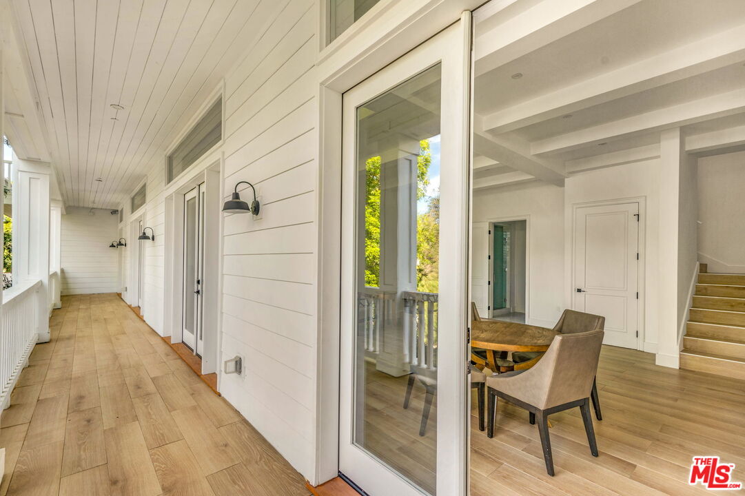 9669 Oak Pass Road Beverly Hills, CA 90210 - Photo 26 of 37 a view of a hallway with wooden floor and chair