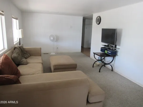 a living room with furniture a flat screen tv and a window