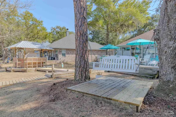 a view of a house with a yard and wooden deck