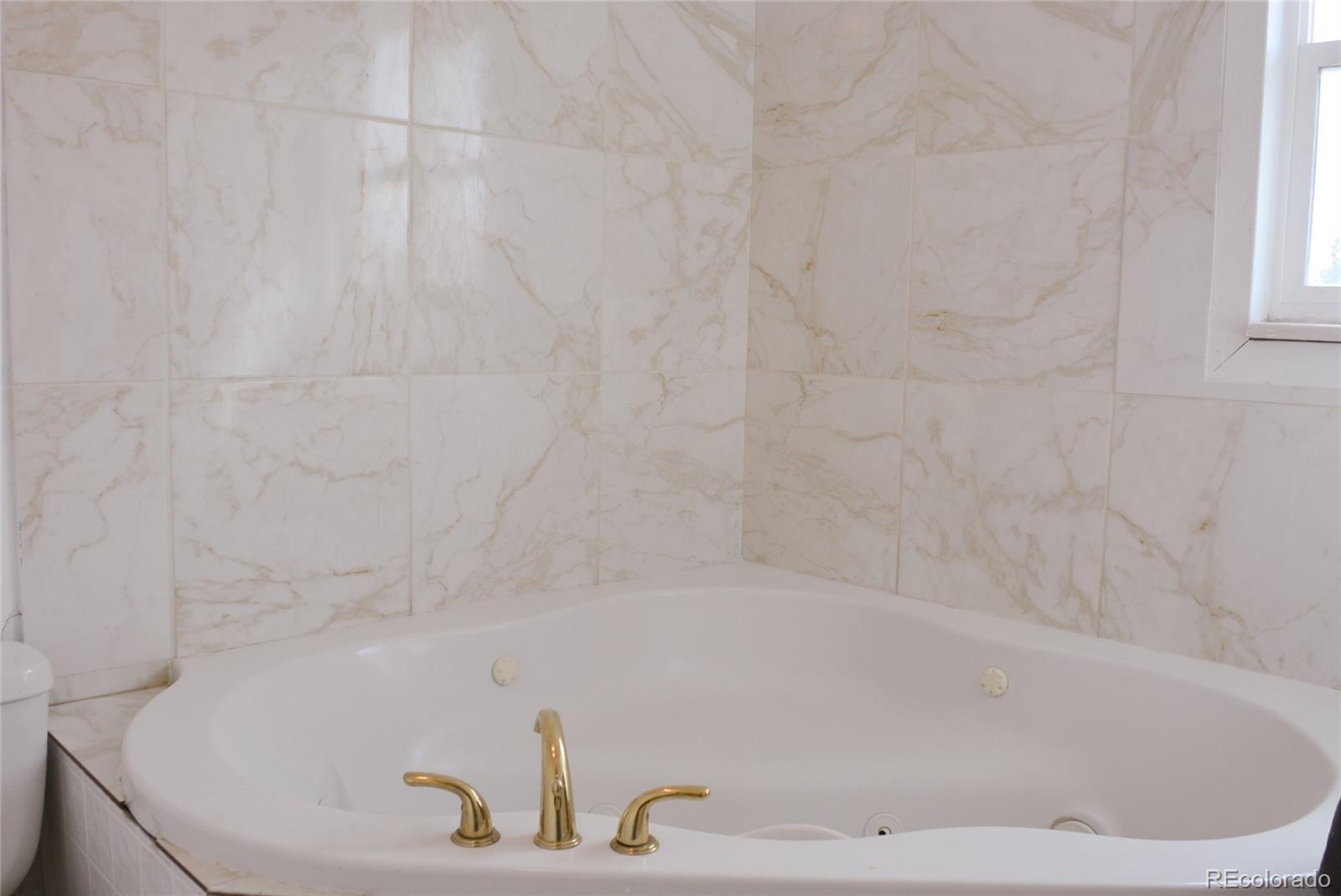 2087 South Quintero Street Aurora, CO 80013 - Photo 19 of 34 a bathroom with a bathtub