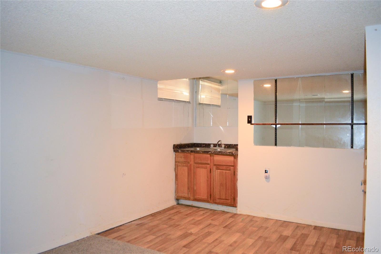 2087 South Quintero Street Aurora, CO 80013 - Photo 28 of 34 an empty room with wooden floor and cabinet