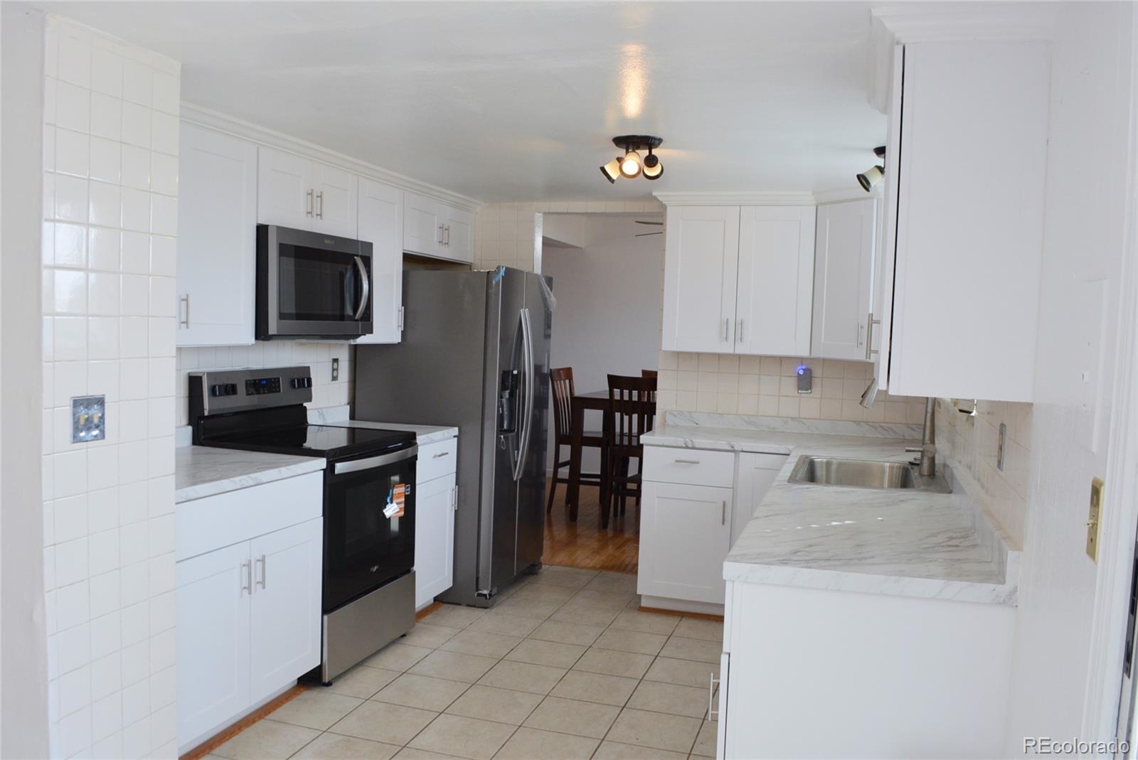 2087 South Quintero Street Aurora, CO 80013 - Photo 4 of 34 a kitchen with a sink a stove and refrigerator