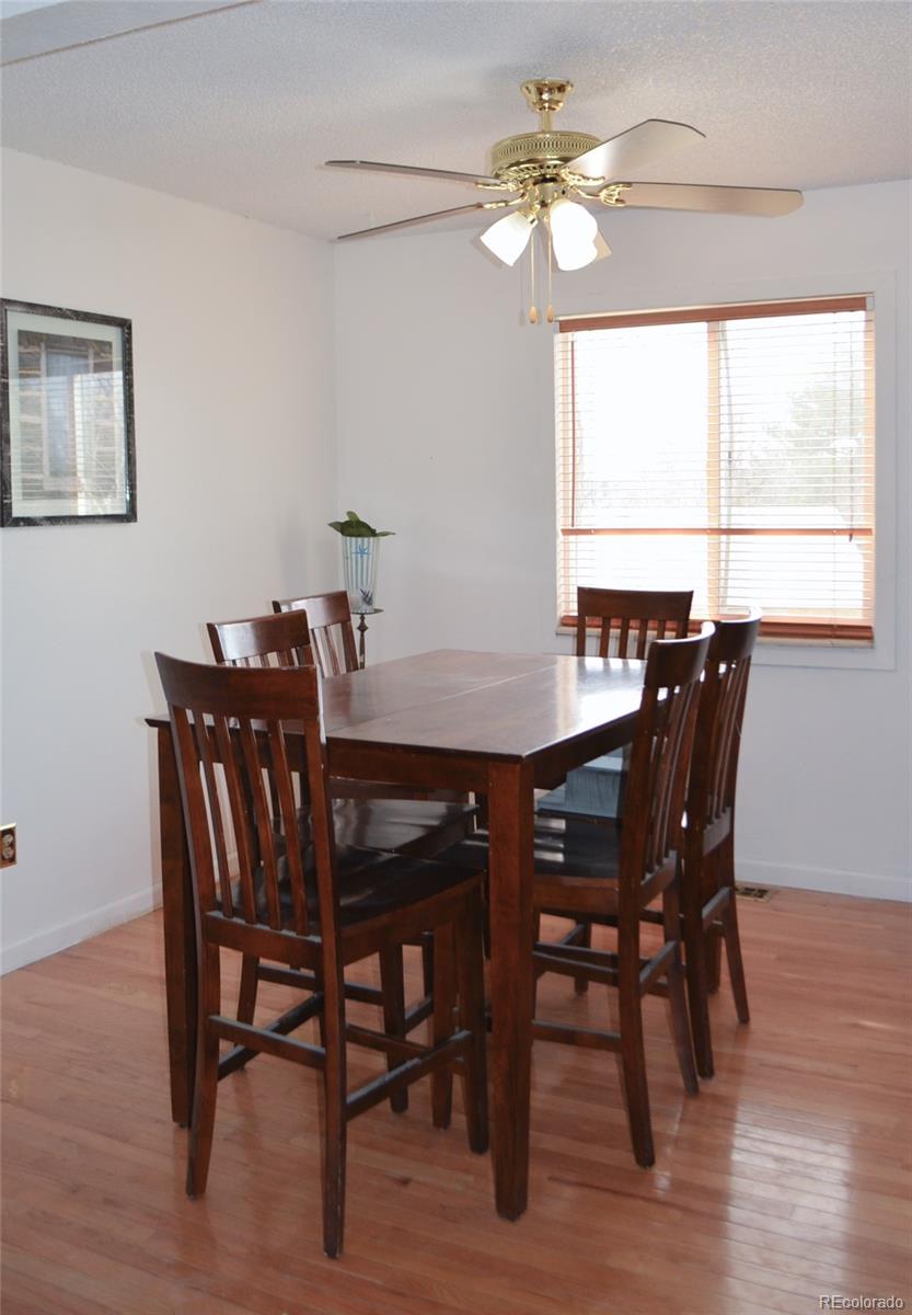 2087 South Quintero Street Aurora, CO 80013 - Photo 10 of 34 a view of a dining room with furniture window and wooden floor