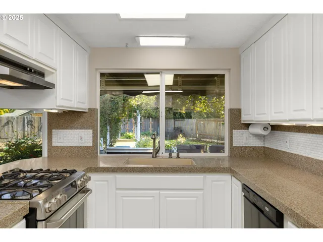 a kitchen with granite countertop a stove and a sink