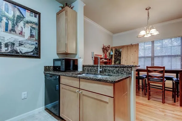 a kitchen with stainless steel appliances granite countertop a stove a sink dishwasher and a microwave with wooden floor
