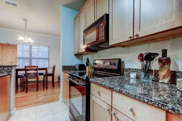 a kitchen with stainless steel appliances granite countertop a stove a sink and a microwave