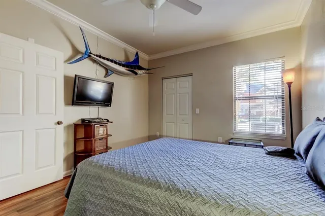 a bedroom with a bed a flat screen tv and a chandelier