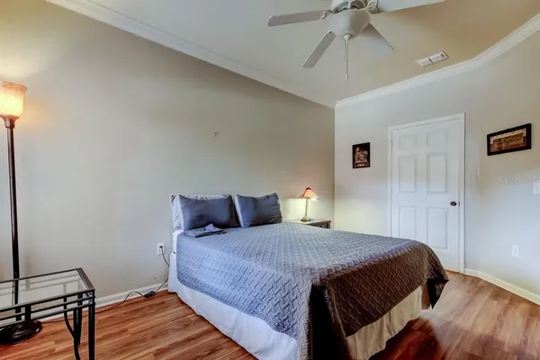 a bedroom with a bed and wooden floor