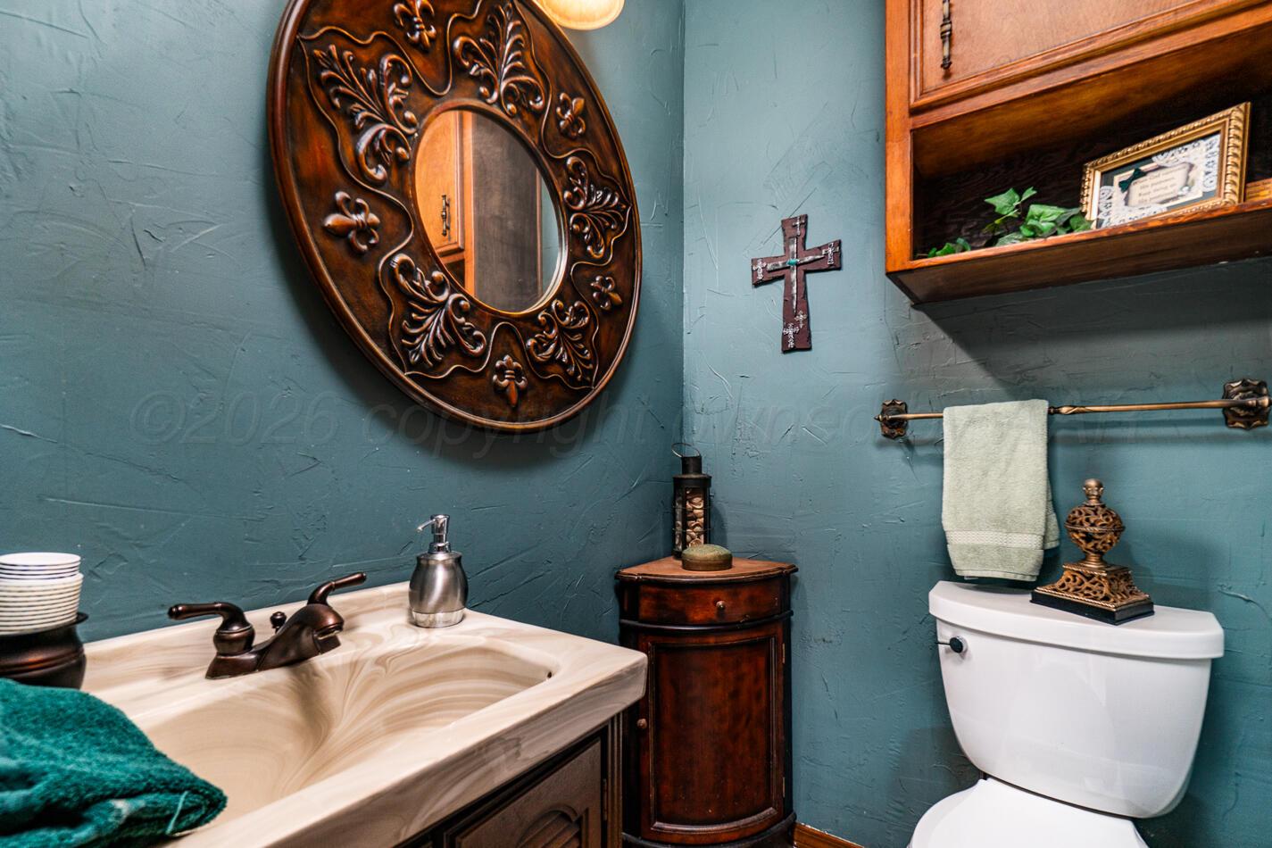 6405 Ridgewood Drive Amarillo, TX 79109 - Photo 11 of 25 a bathroom with a toilet a sink and mirror