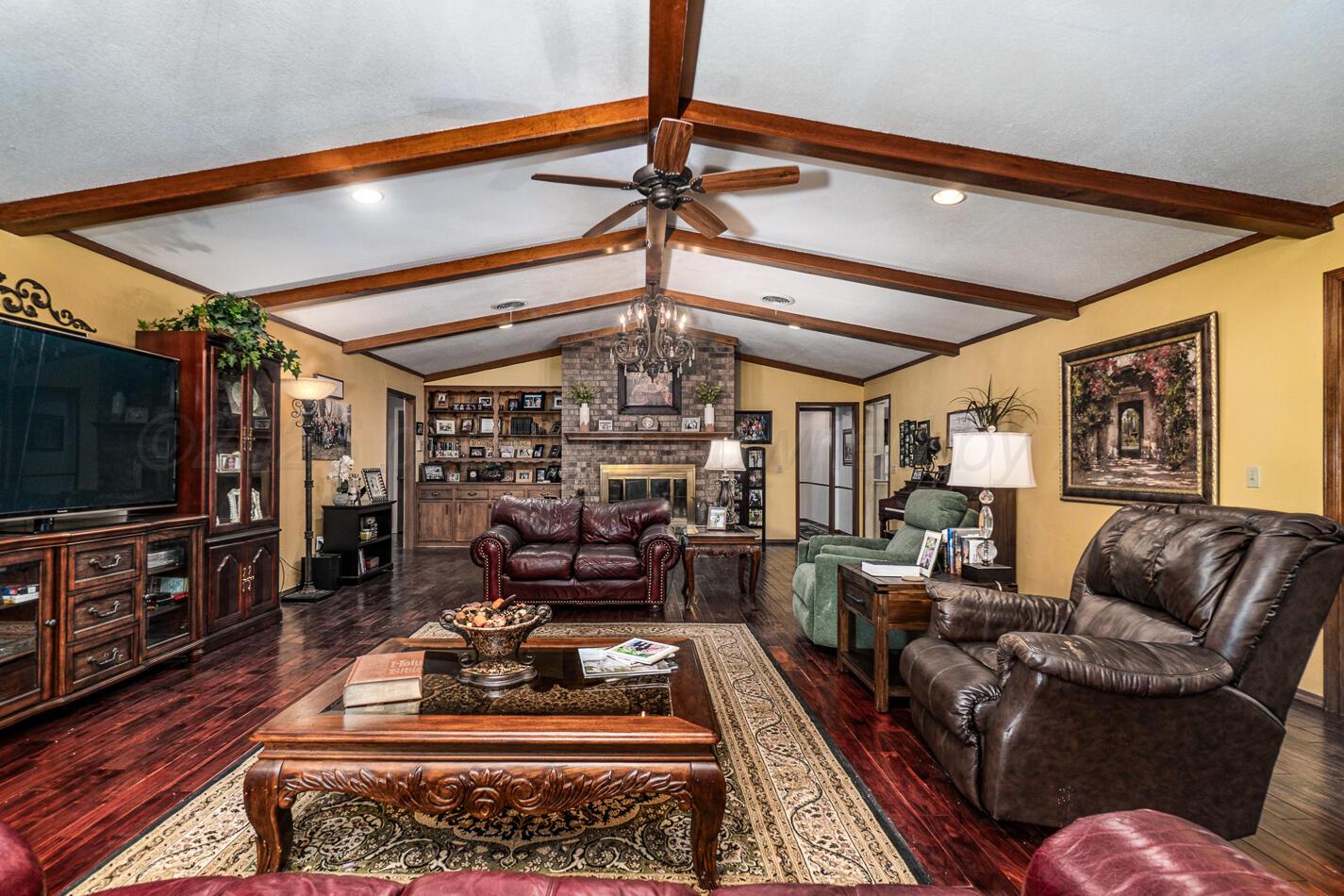 6405 Ridgewood Drive Amarillo, TX 79109 - Photo 3 of 25 a living room with furniture a flat screen tv and a table
