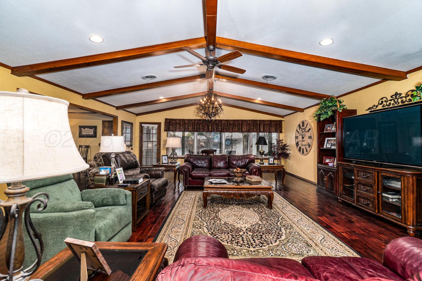 6405 Ridgewood Drive Amarillo, TX 79109 - Photo 6 of 25 a living room with furniture a flat screen tv and a floor to ceiling window