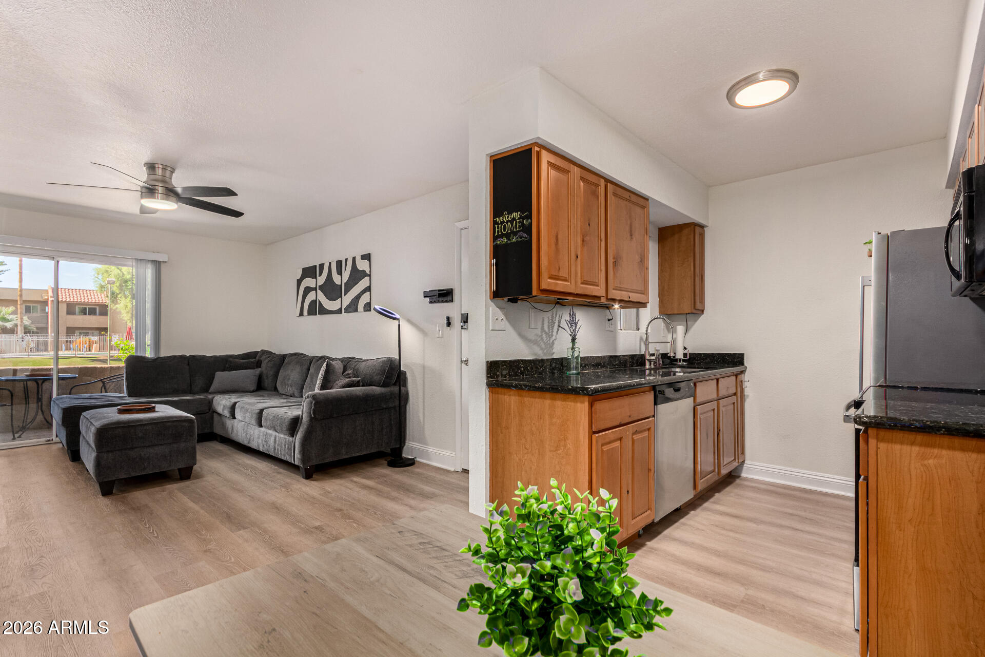 5877 North Granite Reef Road, Unit 1133 Scottsdale, AZ 85250 - Photo 9 of 33 a living room with kitchen island granite countertop wooden floor a stove a sink and a potted plant