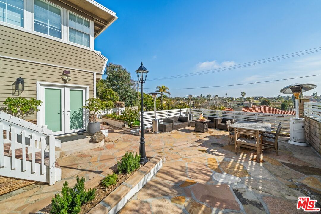 7520 Earldom Avenue Playa del Rey, CA 90293 - Photo 14 of 28 a view of a patio with a dining table and chairs with wooden floor and fence