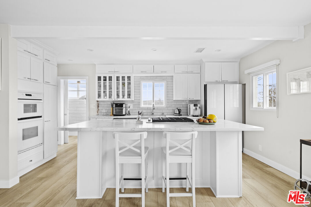 7520 Earldom Avenue Playa del Rey, CA 90293 - Photo 6 of 28 a kitchen with stainless steel appliances a white stove top oven cabinets and a refrigerator