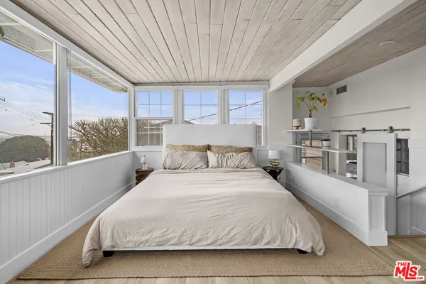 a large bed sitting in a bedroom next to a large window