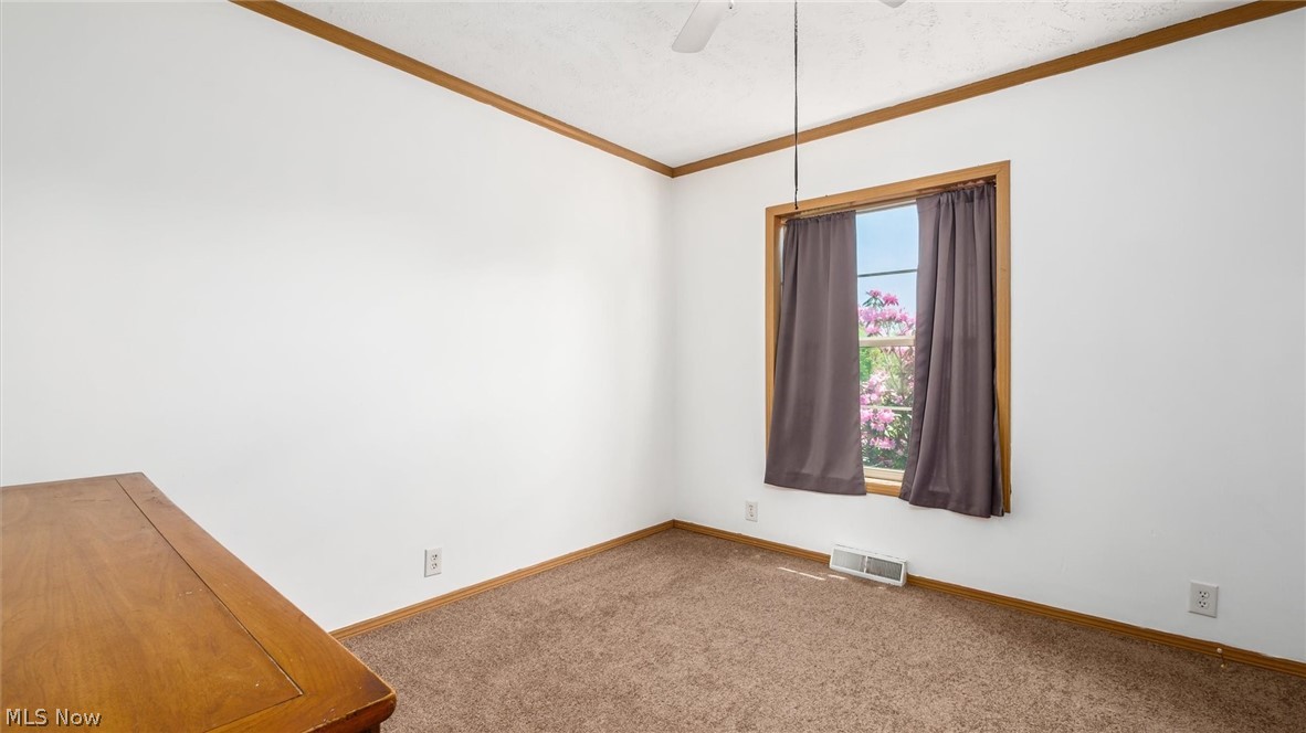 9180 North River Road East Dresden, OH 43821 - Photo 25 of 36 Carpeted empty room featuring ornamental molding and ceiling fan