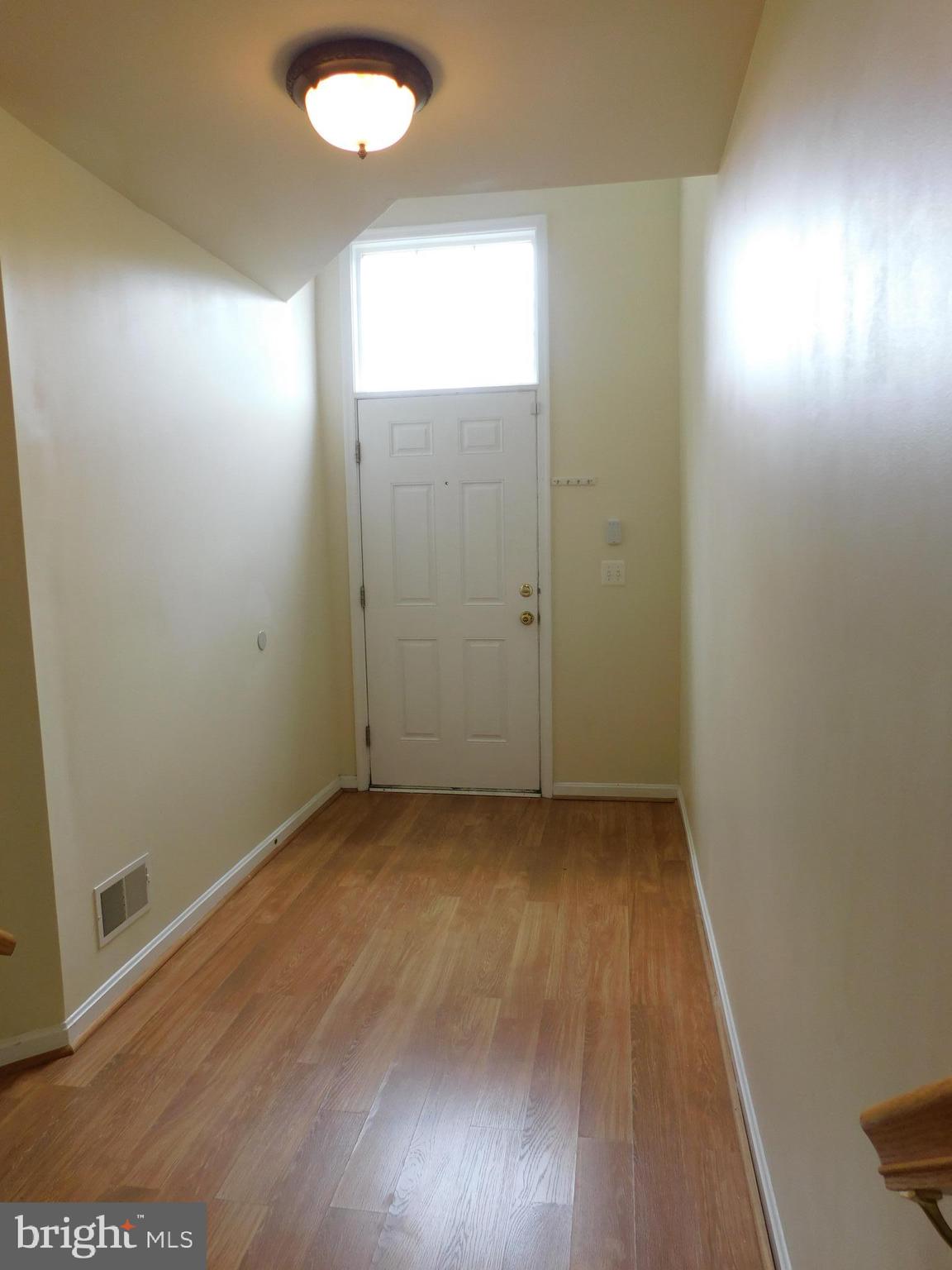 4036 Cutty Sark Road Baltimore, MD 21220 - Photo 2 of 25 an empty room with wooden floor and windows