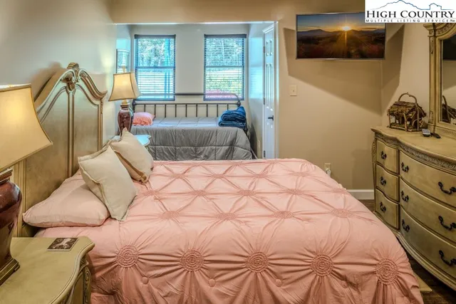 a bedroom with a bed and a flat tv screen on the dresser