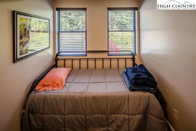 a bedroom with a bed and two windows