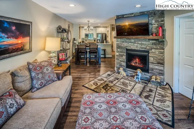 a living room with furniture a flat screen tv and a fireplace