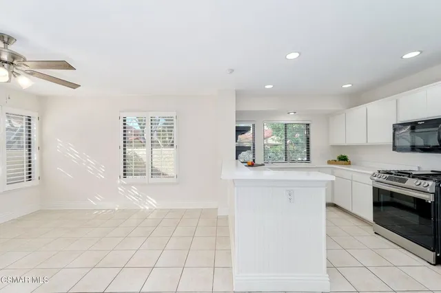 a large white kitchen with cabinets and a window