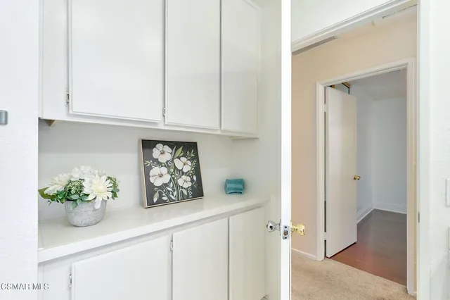 an empty room with a chandelier fan and windows