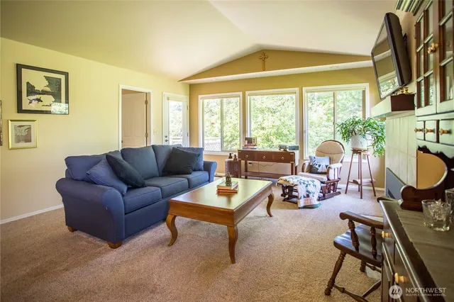 a living room with furniture a fireplace and a large window