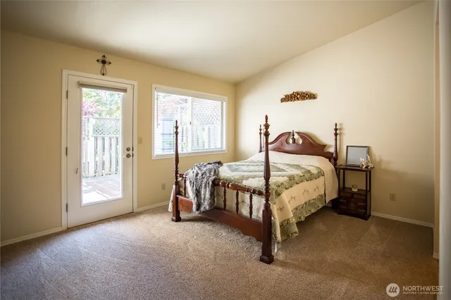 a bed sitting in a spacious bedroom next to a window