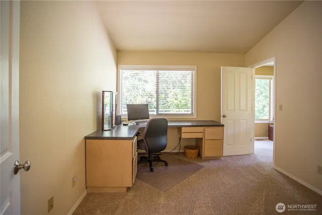 a view of a workspace with furniture and a window