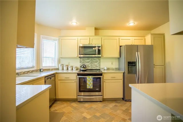 a kitchen with stainless steel appliances granite countertop a refrigerator and a stove top oven