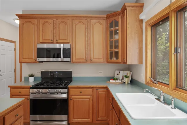 a kitchen with stainless steel appliances granite countertop a sink stove and microwave