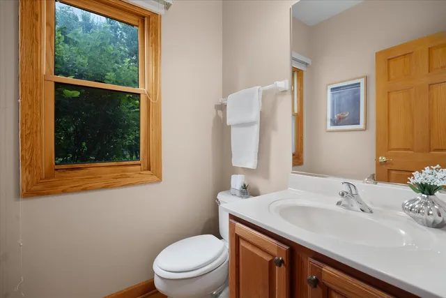 a bathroom with a granite countertop sink toilet and mirror