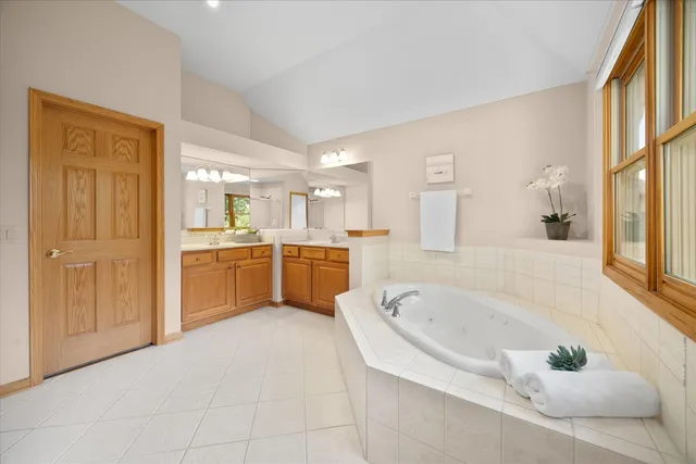 a large white tub sitting in a bathroom next to a sink