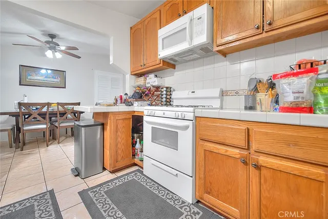 a kitchen with stainless steel appliances granite countertop a sink a stove cabinets dining table and chairs