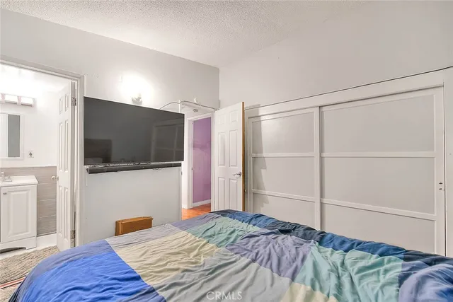 a bedroom with a bed and a flat screen tv