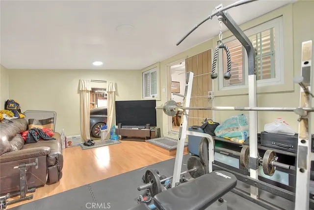 a living room with furniture a flat screen tv and a floor to ceiling window