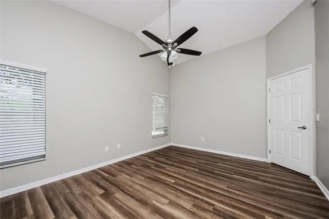 a view of a room with wooden floor and a ceiling fan