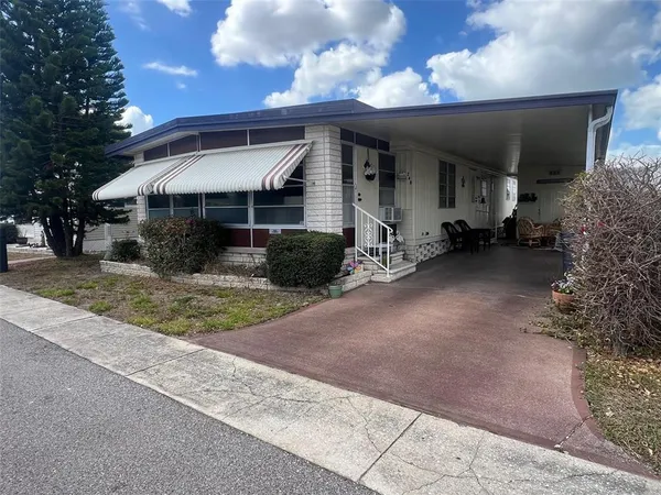 a view of a house with a patio and a yard