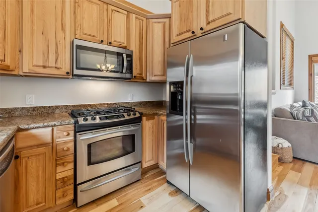 a metallic refrigerator freezer sitting inside of a kitchen