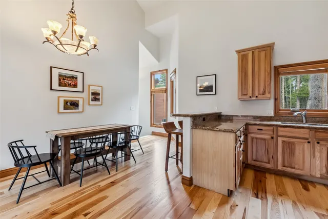 a kitchen with a table chairs stove and wooden floor
