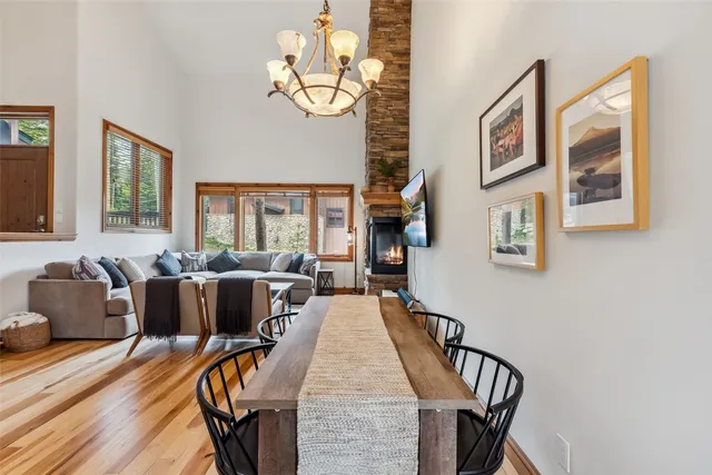 a living room with couches a dining table and chairs with wooden floor