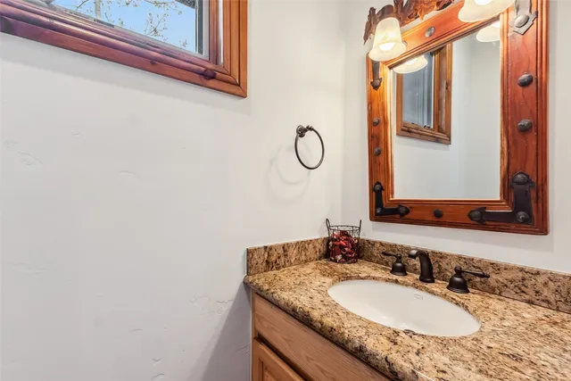 a bathroom with a granite countertop sink and a mirror