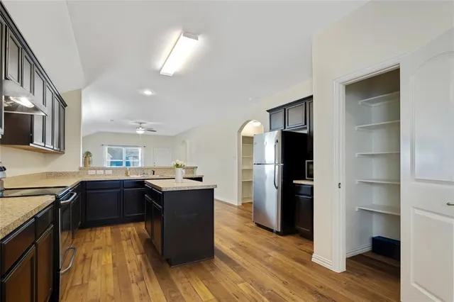 a kitchen with a refrigerator and a stove top oven