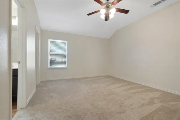an empty room with windows and fan