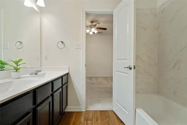 a bathroom with a tub sink and mirror