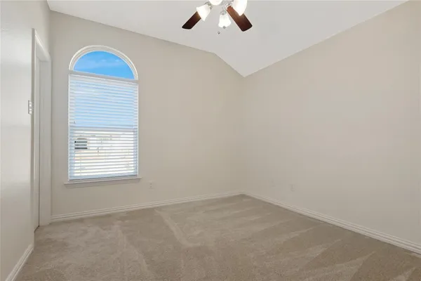 an empty room with a window and a ceiling fan